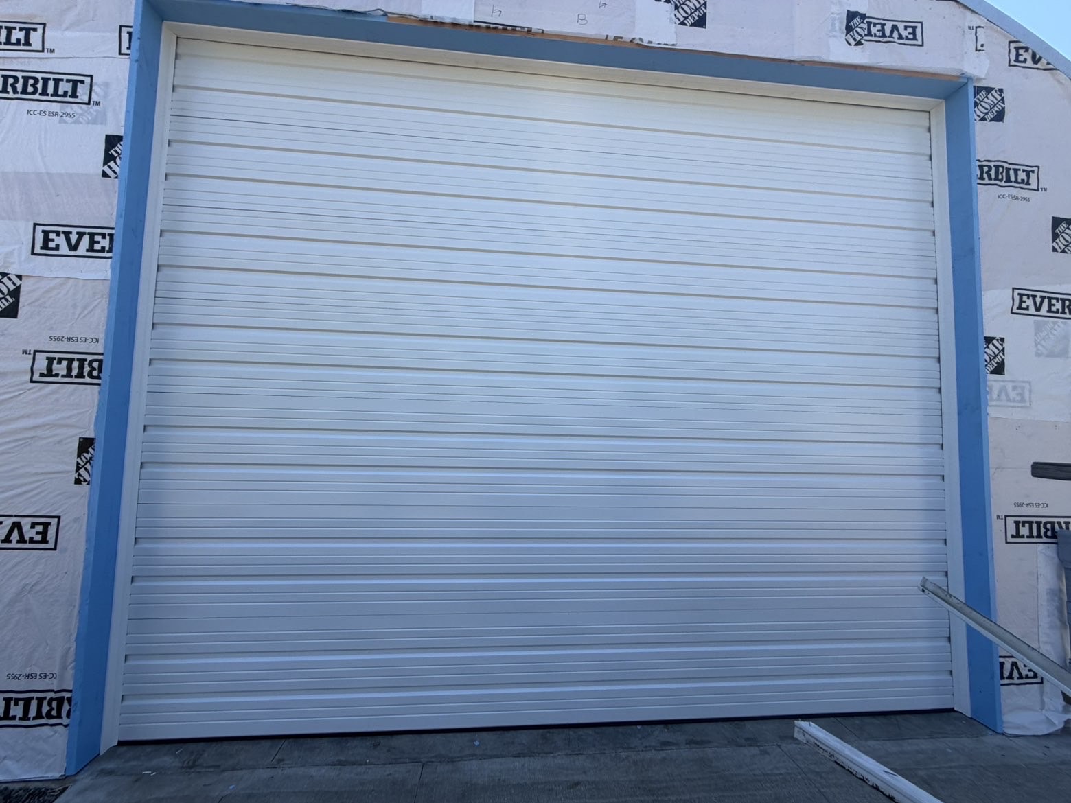 White ribbed commercial garage door on a building under construction