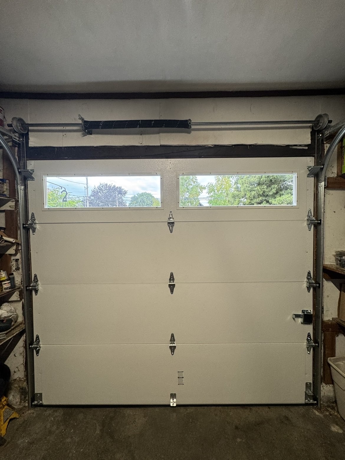 Almond flush-panel garage door with windows and torsion spring