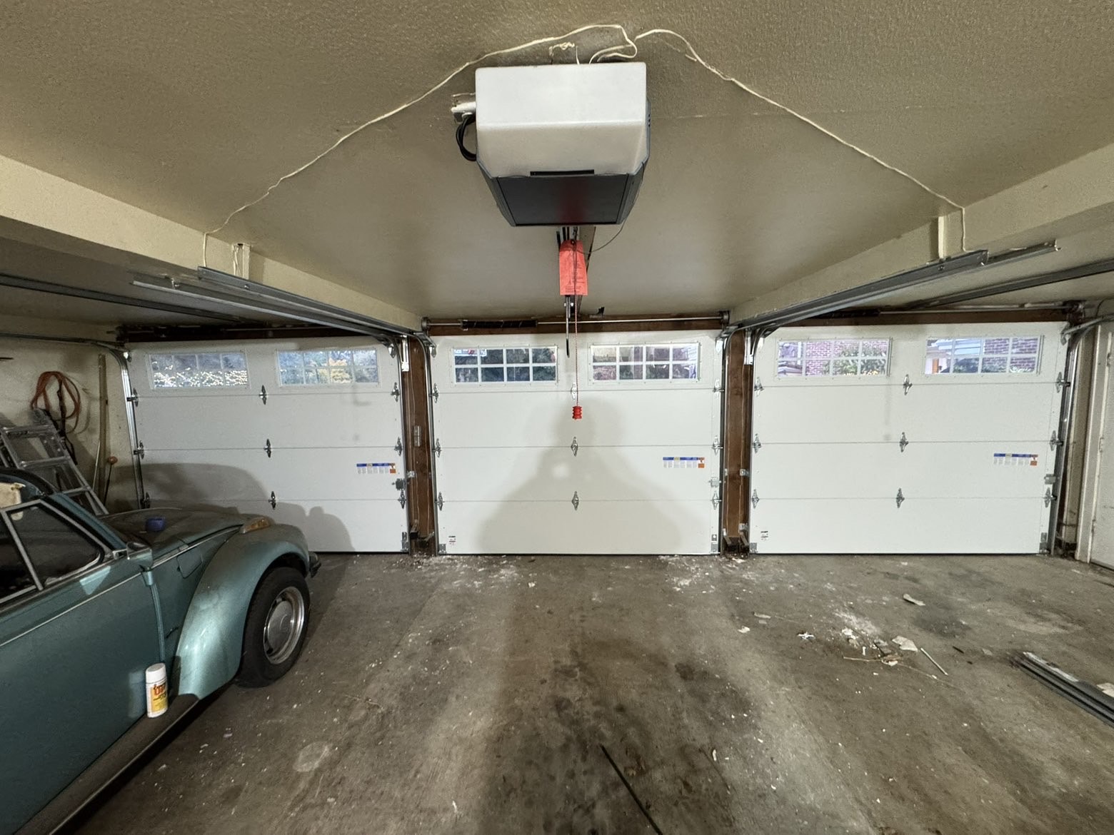 Interior of a two-car garage with new white doors and opener