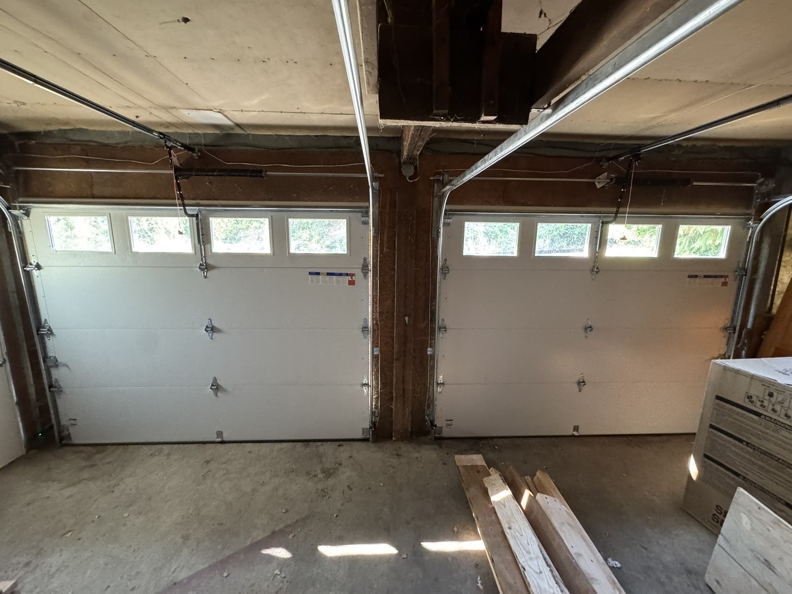 Interior view of two new white garage doors with window rows